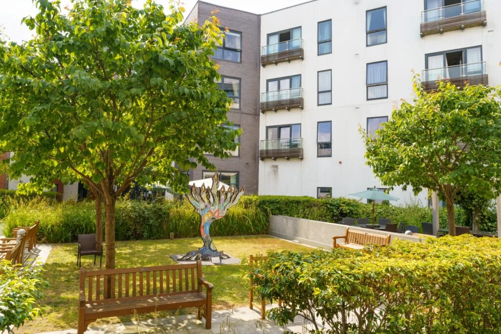 An exterior image showing the courtyard gardens with the building in the background